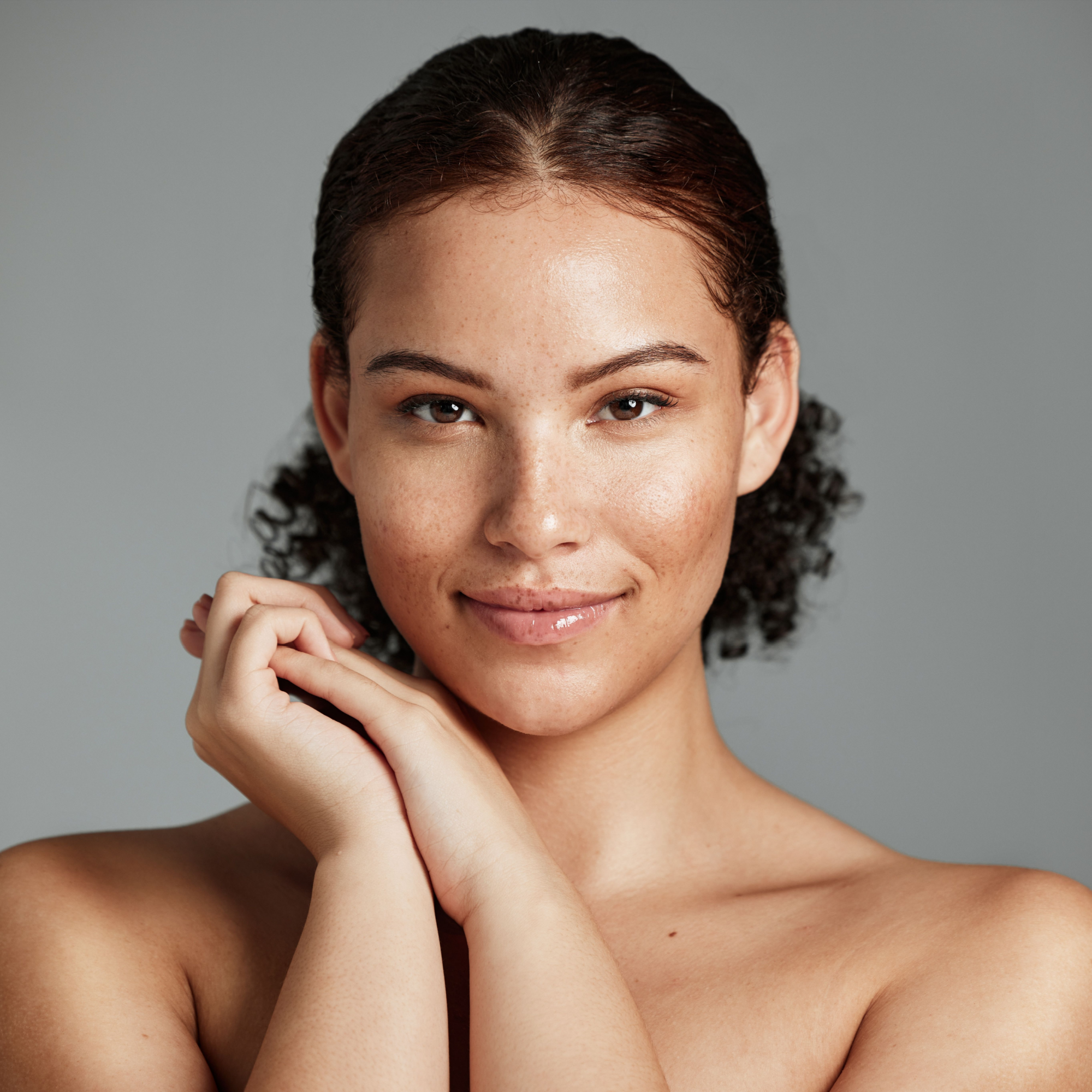 Radiant black woman showcasing her natural, glowing skin after using No More Make Up Skin Corrector, embodying the product's promise for luminous, healthy-looking complexion.